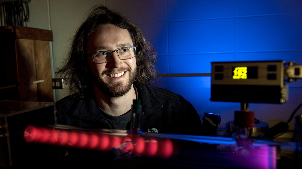 Graduate student Josh Larson with the plasma tube he built.